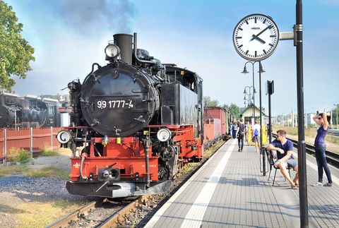 Eine Dampflok in Schwarz-Rot fährt im Bahnhof in Radebeul ein.