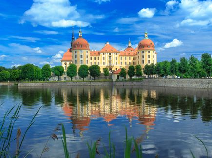 Blick auf Schloss Moritzburg, mit dem Schlossteich im Vordergrund bei Sonnenschein 