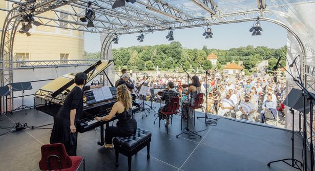 Streicher und eine Pianistin sitzen auf einer Open-Air- Bühne vor dem Moritzburger Publikum. 