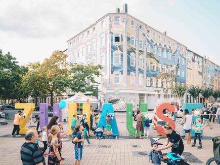 Boulevard Brühl in Chemnitz, Schriftzug "Zuhause" steht in lebensgroßen Lettern inmitten des Boulevards, Menschen laufen umher