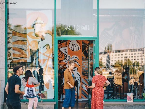 Eine Geschäft mit großen Fenstern, vor dem Menschen stehen, die durch die Schaufenster nach innen schauen.