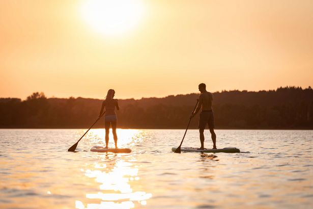 Zwei Personen beim Stand-Up-Paddling auf einem See