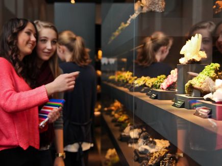 Junge Besucherinnen betrachten die Vitrinen mit den zahlreichen Mineralien.