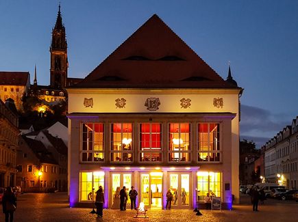 Außenansicht des beleuchteten Theaters am Abend