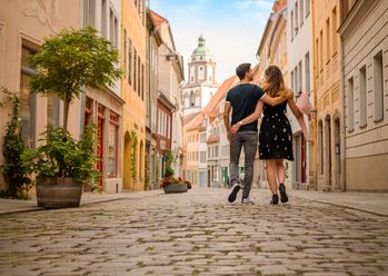 Ein verliebtes Paar bummelt Arm in Arm durch die wunderschön sanierte, historische Altstadt von Meißentstadt 