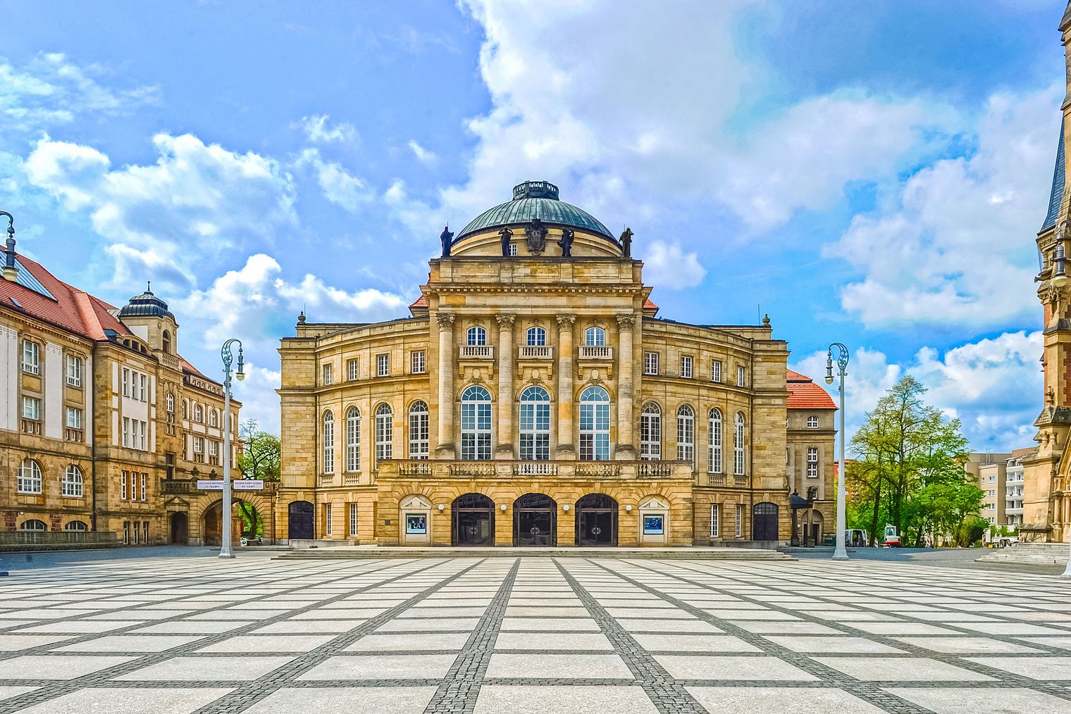 Opernhaus Chemnitz bei Tag mit großer Kuppel und hellem Platz davor. / Chemnitz Opera House in daylight with large dome and open square in front.