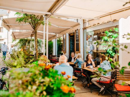 Außensitzplätze eines Restaurants mit Gästen