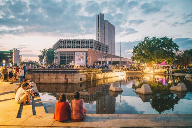 Vorplatz Stadthalle Chemnitz im Abendlicht, reges Treiben - junge Menschen verweilen im Sommer. 