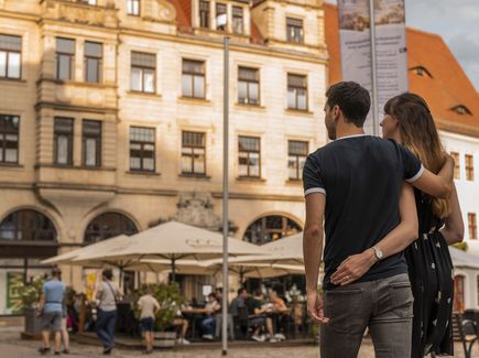 Ein Pärchen umarmt sich und schlendert gemeinsam durch die Stadt.