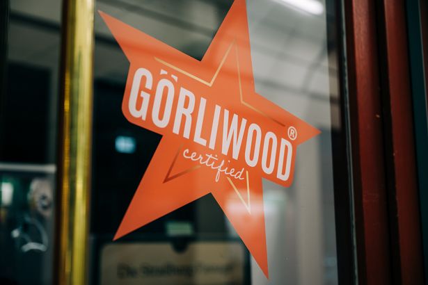 Ein roter Stern mit der Aufschrift "Görliwood certified" klebt an einem Schaufenster. Es ist ein Zeichen des Walk of Görliwood in Görlitz. 