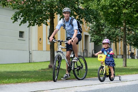 Ein Kind und sein Vater fahren mit dem Fahrrad durch Rammenau. 