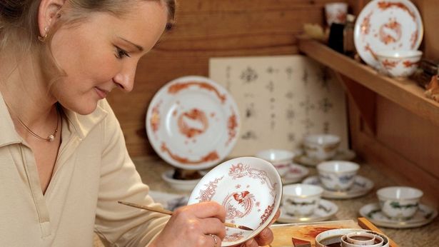 Eine Porzellan Malerin aus Meissen bemalt einen Teller