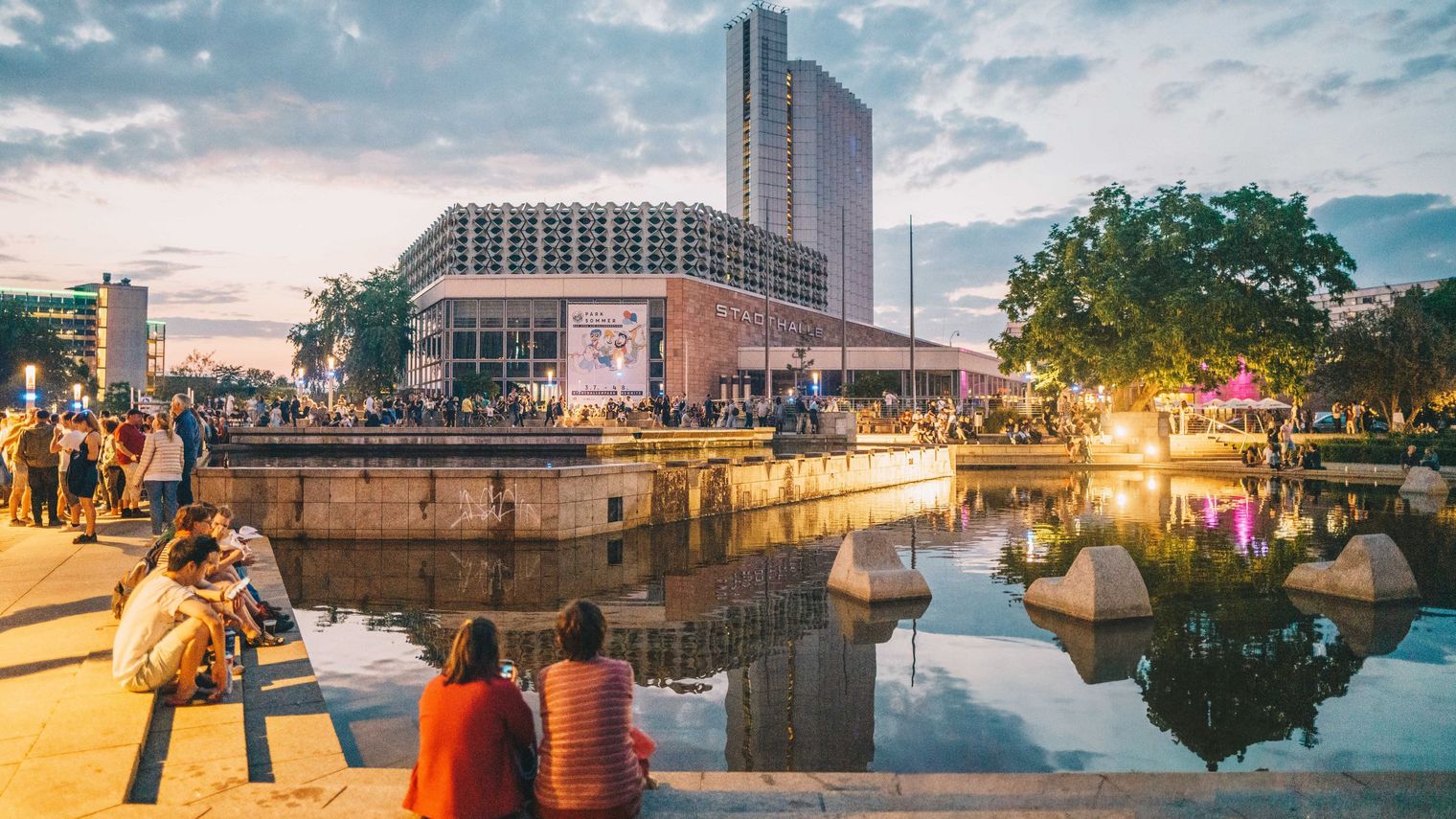 Vorplatz Stadthalle Chemnitz im Abendlicht, reges Treiben - junge Menschen verweilen im Sommer. 