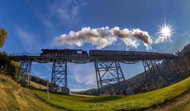 Die Erzgebirgische Aussichtsbahn fährt auf dem Viadukt bei Markersbach. Gäste können die Landschaft des Erzgebirges beobachten. 