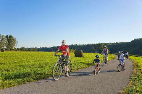 Eine Familie fährt auf dem Mulderadweg bei Höfgen. 