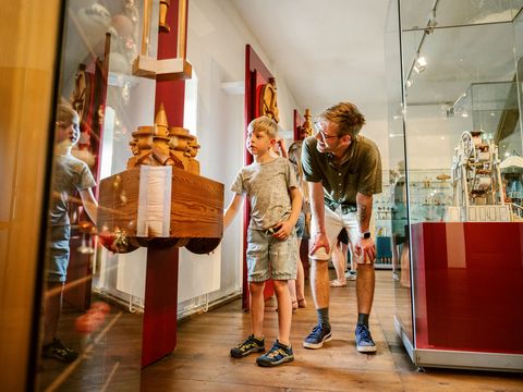 Ein Junge schaut sich mit seinem Vater die Ausstellung auf der Burg Scharfenstein im Erzgebirge an