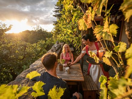 Pärchen sitzt auf Terrasse im Grünem