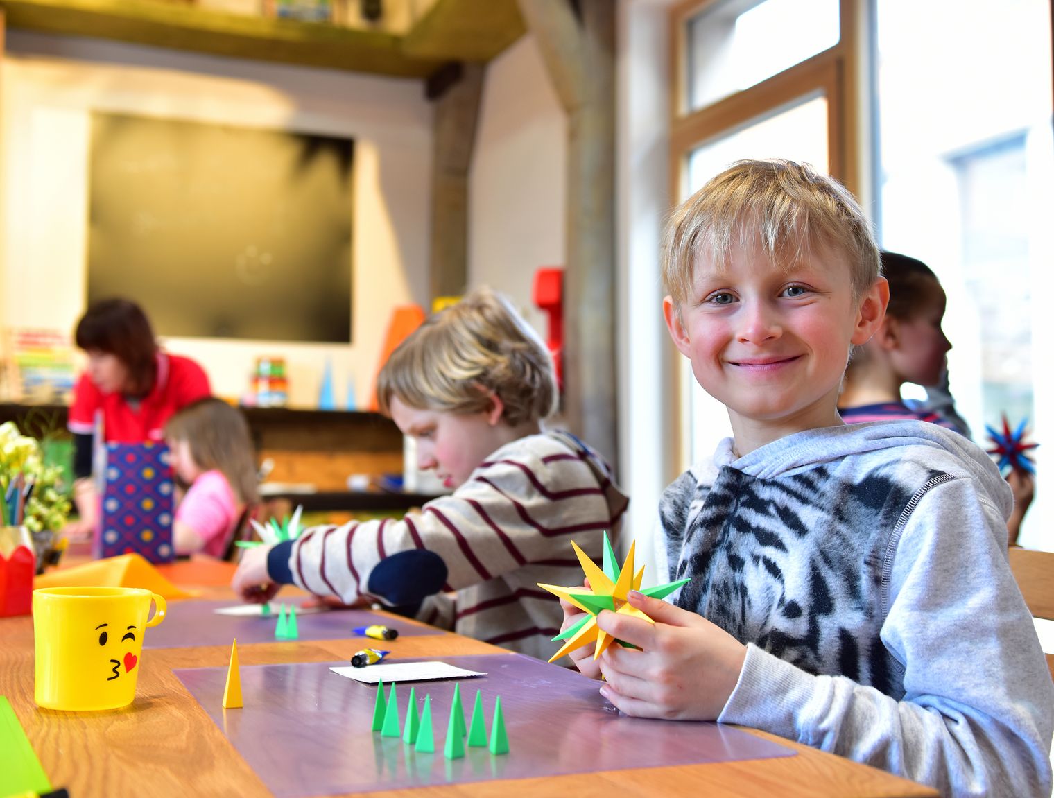 Kinder gestalten Herrnhuter Sterne in der Manufaktur