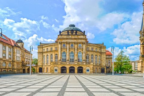Opernhaus Chemnitz bei Tag mit großer Kuppel und hellem Platz davor. / Chemnitz Opera House in daylight with large dome and open square in front.