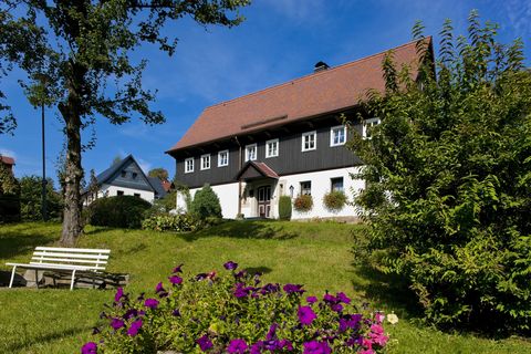 Ein Haus steht auf einer Wiese in Lückendorf. 