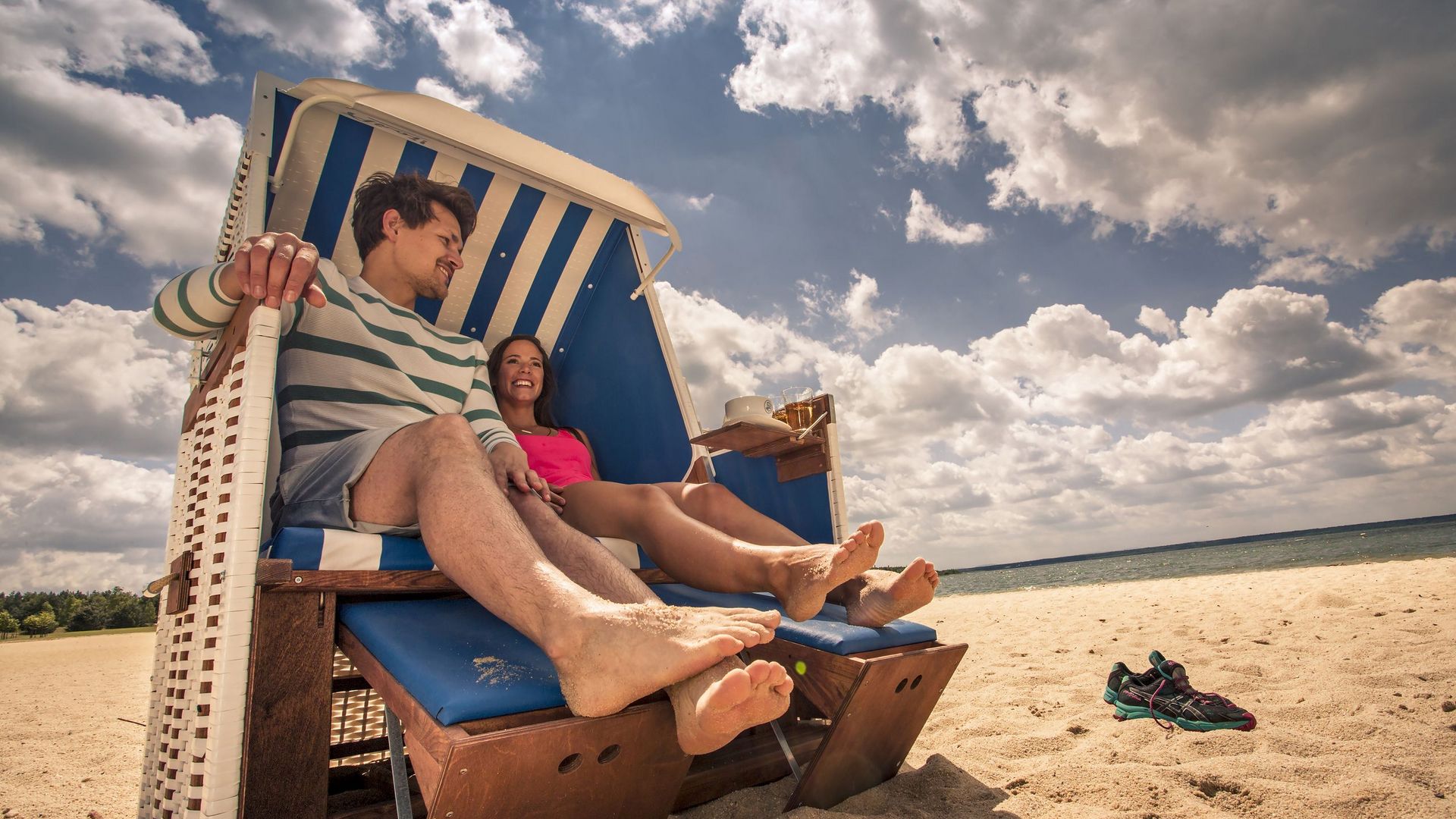 Eine Frau und ein Mann sitzen in einem Strandkorb am Bärwalder See. Sie machen Urlaub im Lausitzer Neuseenland.