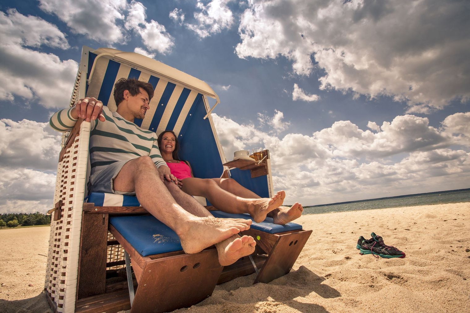 Eine Frau und ein Mann sitzen in einem Strandkorb am Bärwalder See. Sie machen Urlaub im Lausitzer Neuseenland.