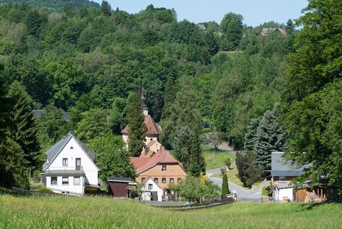 Zwischen Häusern und Wäldern steht eine Kirche. Man blickt auf das Dorf Blankenhain.