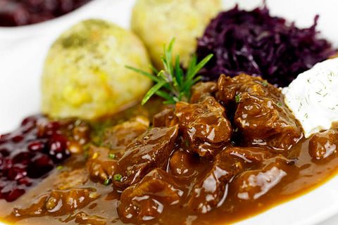 Ein Teller mit Gulasch und Klößen.