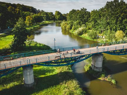 Radfahrer überqueren eine Brücke bei Bad Muskau. Sie sind auf dem Oder-Neiße-Radweg.