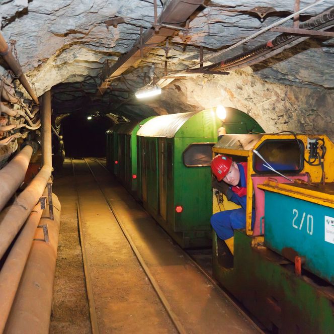 Eine bunte Grubenbahn fährt durch die Zinnkammern des Stollens im Besucherbergwerk in Schwarzenberg. w