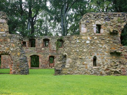 Auf einer Wiese stehen Mauerreste aus Stein. Sie gehören zum Kloster Nimbschen bei Grimma. 