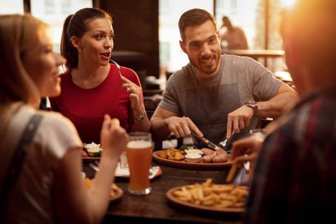 Gruppe sitzt gemütlich zum essen in einem Restaurant zusammen.