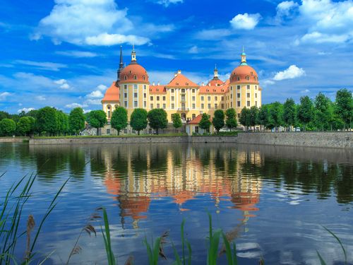 Blick auf Schloss Moritzburg, mit dem Schlossteich im Vordergrund bei Sonnenschein 