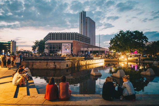 Menschen sitzen am Abend am Wasser