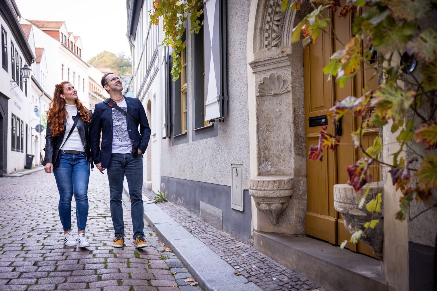 Paar spaziert in Altstadtgasse in Meißen im Herbst / Couple walking in an old town alley in Meißen in autumn