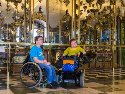 Zwei Personen im Rollstuhl beim Besuch des Grünen Gewölbes in Dresden 