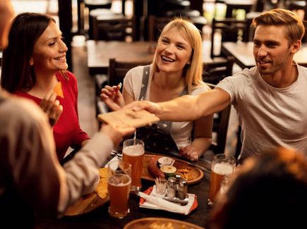 Gruppe sitzt zusammen und stößt mit einem Bier an