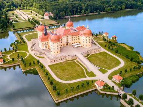 Luftaufnahme des Jagschlosses Mooritzburg. Der barocke Vierflügelbau mit seinen vier direkt mit dem Hauptbau verbundenen Türmen, ist von einem Schlossteich umgeben.