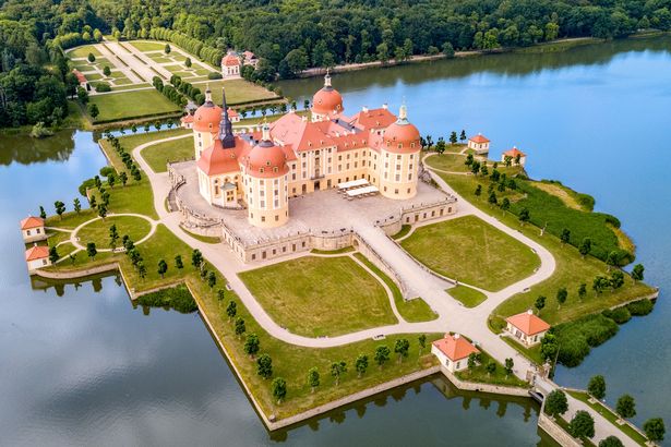 Luftaufnahme des Jagschlosses Mooritzburg. Der barocke Vierflügelbau mit seinen vier direkt mit dem Hauptbau verbundenen Türmen, ist von einem Schlossteich umgeben.