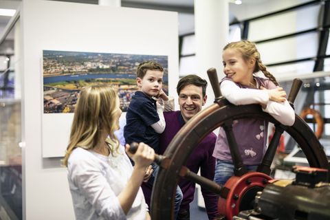 Familie steht am Steuerrad im Verkehrsmuseum Dresden