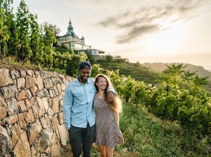 Ein Pärchen umarmt sich und läuft durch die Weinberge