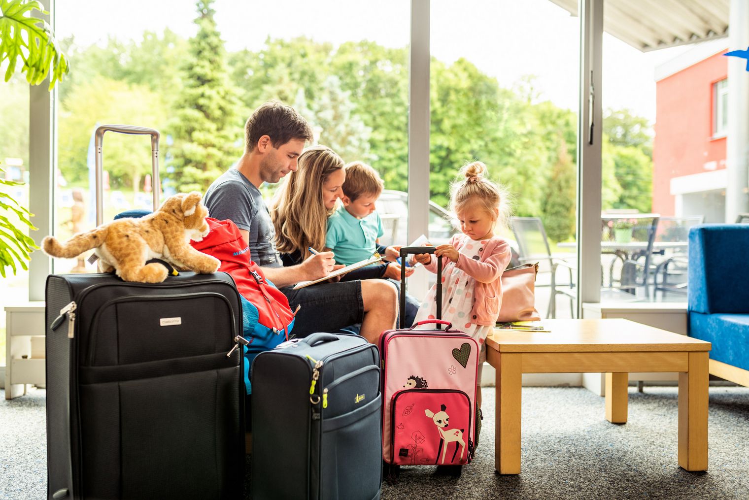 Eine Familie sitzt in einer Lobby in Eibenstock. Sie füllen Dokumente aus.
