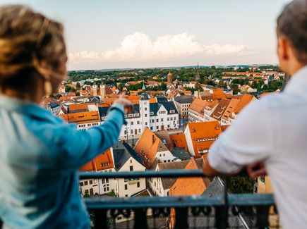 Pärchen blickt von einem Turm über die historische Altstadt und die nähere Umgebung