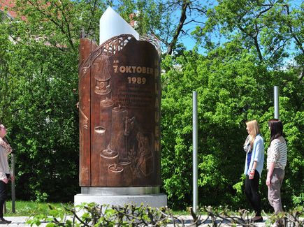 Das Wende-Denkmal hat die Form einer Kerze. Sie besteht aus einer von innen beleuteten Acryl-Stele und wird umschlossen von einem dreiteiligen Bronzemantel