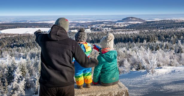 Eine Familie auf einer Bank vor einer Winterlandschaft