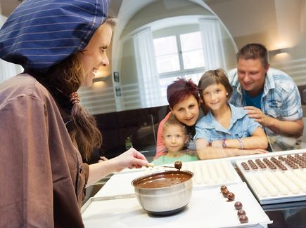 Familie beobachtet die Herstellung von Pralinen