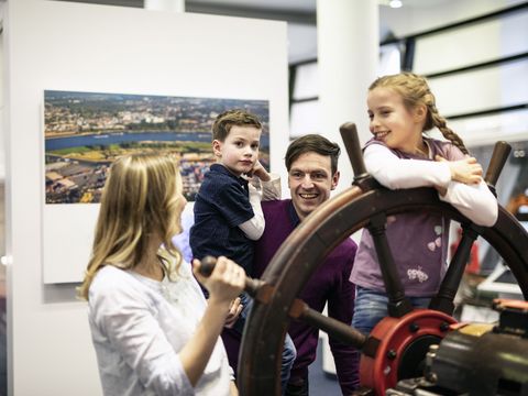 Familie steht am Steuerrad im Verkehrsmuseum Dresden