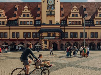 Radfahrer mit Kind vor dem Alten Rathaus Leipzig