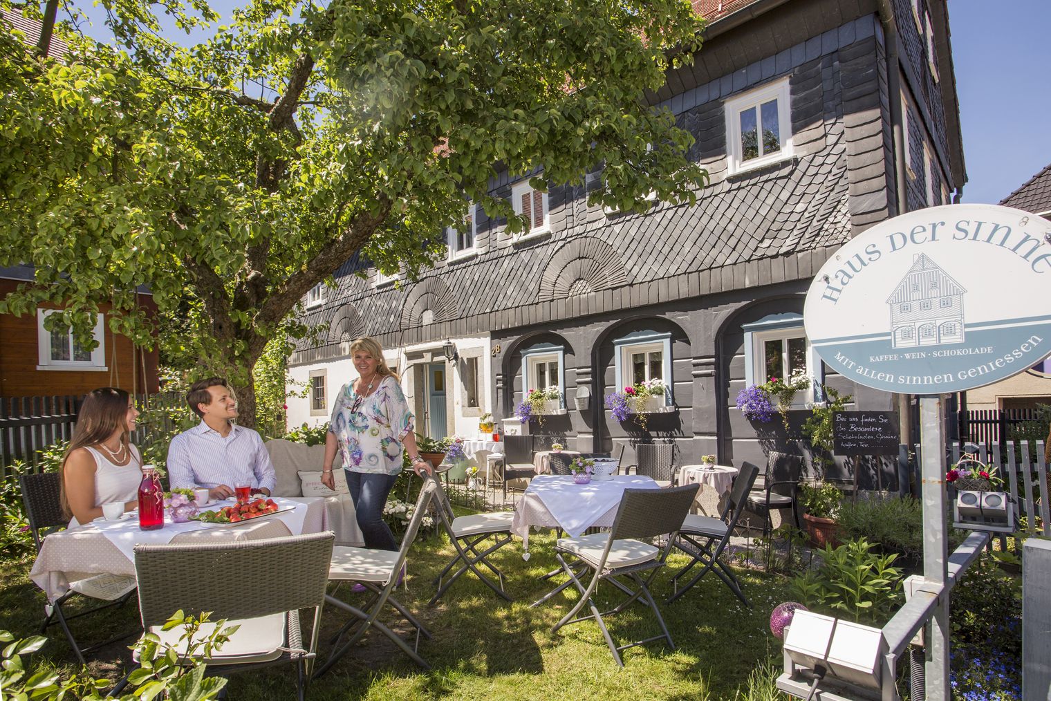 Pärchen sitzt im Garten vor dem Haus der Sinne