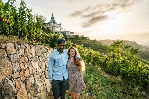 Ein Pärchen umarmt sich und läuft durch die Weinberge.